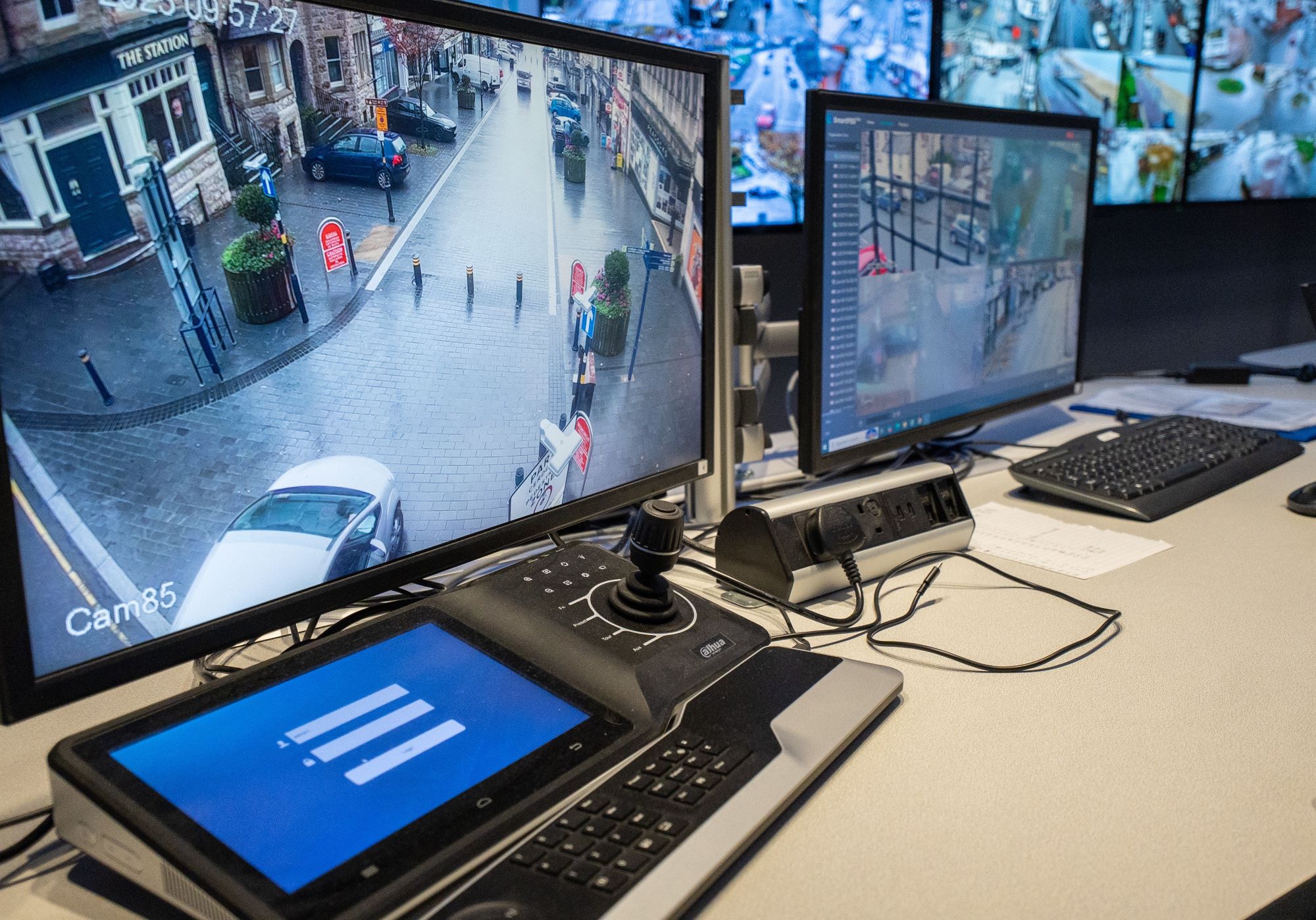 CCTV control room operator working at a bank of monitors.
