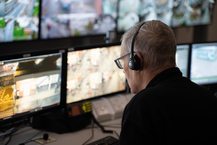 CCTV operator at a bank of CCTV screens.